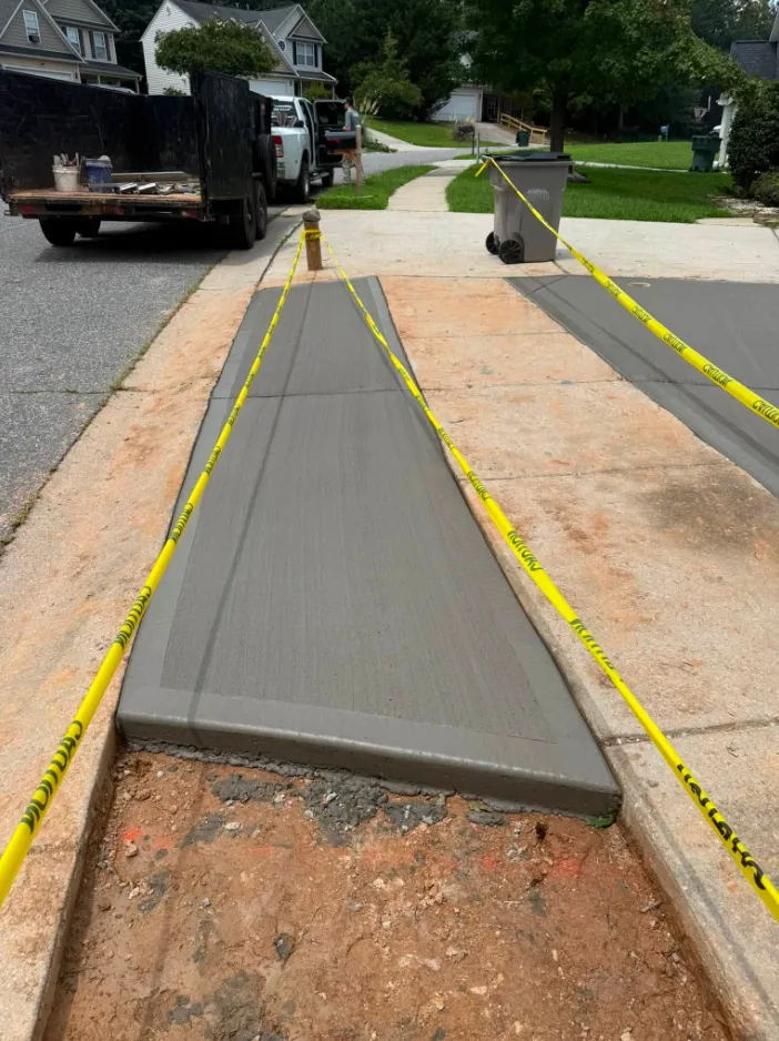 A freshly poured concrete walkway on a Broke Down Construction job site