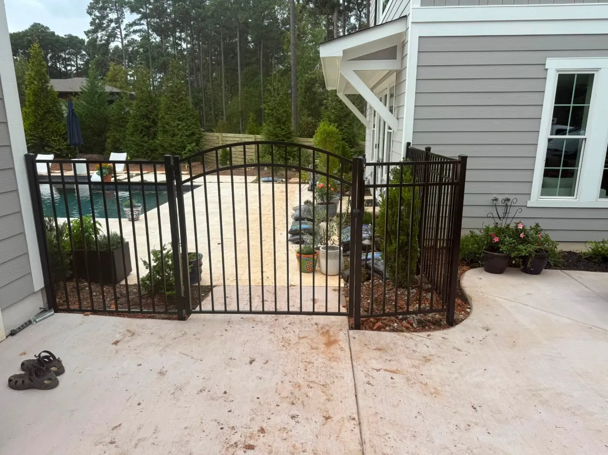 Aluminum fence and gate installed around a pool patio